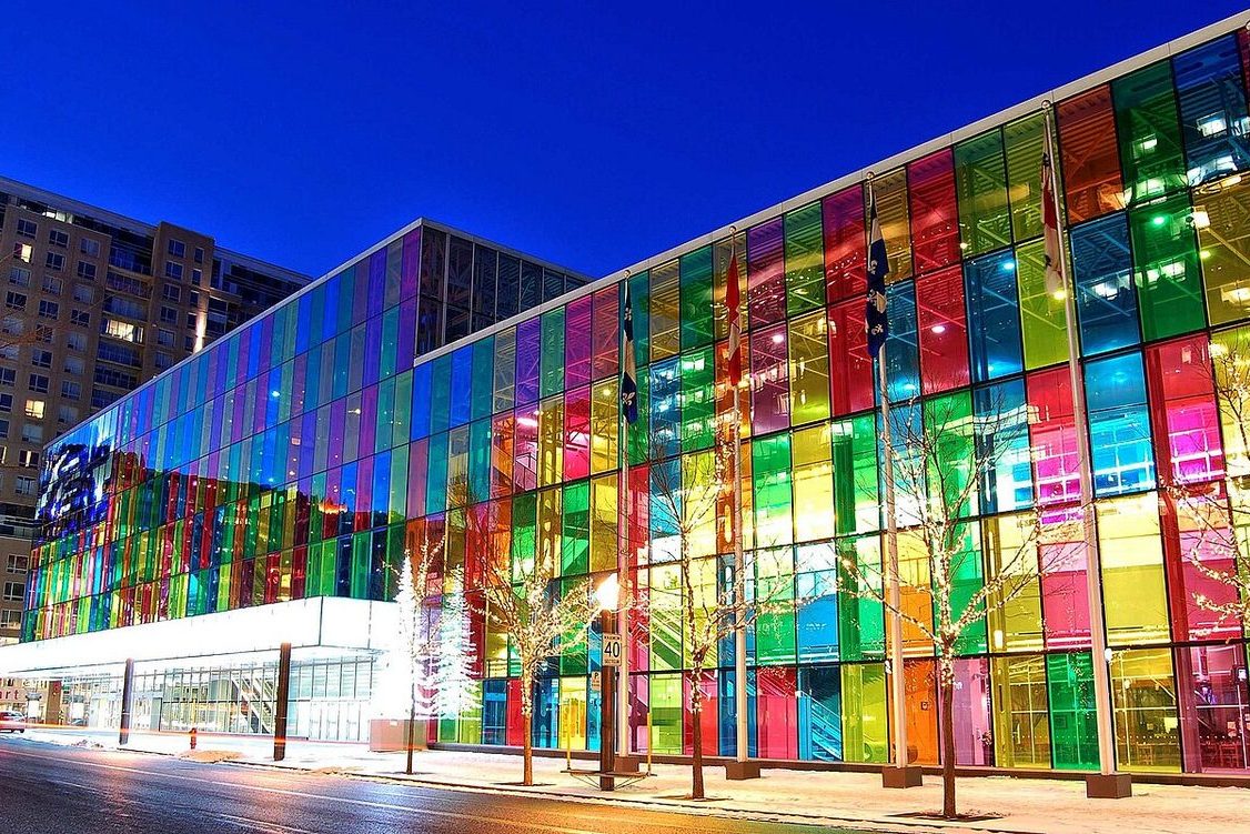 Montreal convention center with colored glass panels lit at dusk